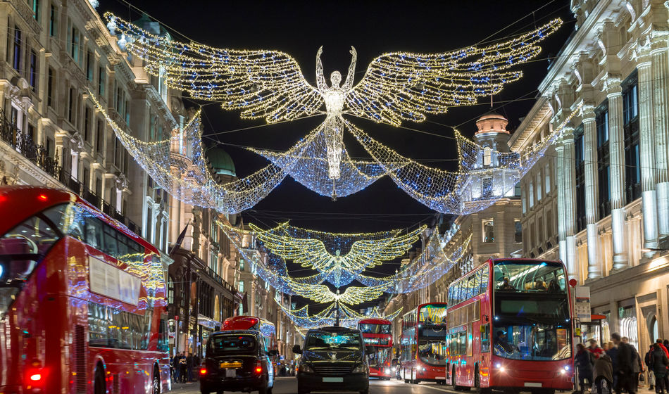Double-decker buses pass beneath Christmas lights on Regent Street, London, U.K.