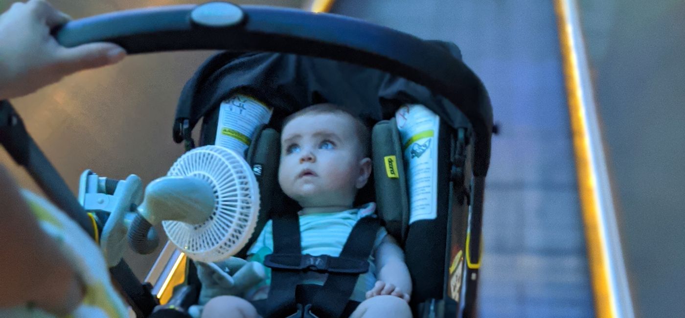 Image: A battery-powered fan attached to a stroller walking through the airport (Photo via Eric Bowman)