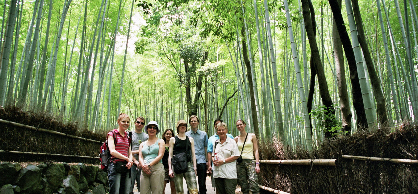 Image: A small group with InsideJapan Tours poses in a bamboo forest in Arashiyama, Kyoto. (Photo Credit: InsideJapan Tours)
