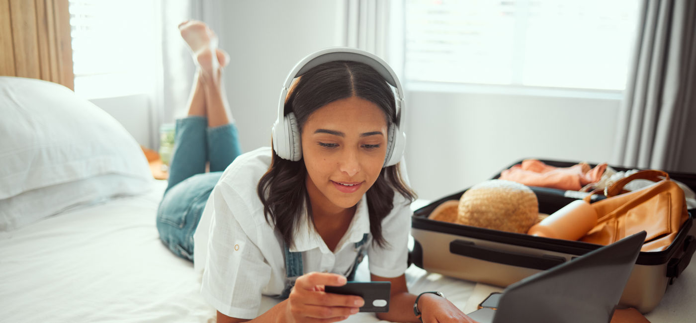 Image: A woman booking travel with a credit card. (Photo Credit: Kay A/peopleimages.com/Adobe Stock)