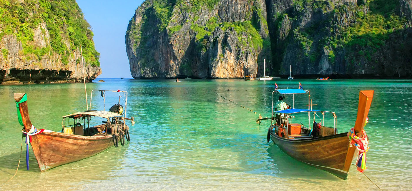 Image: Longtail boats anchored at Maya Bay on Phi Phi Leh Island, Krabi Province, Thailand. (Photo Credit: donyanedomam / Adobe Stock)