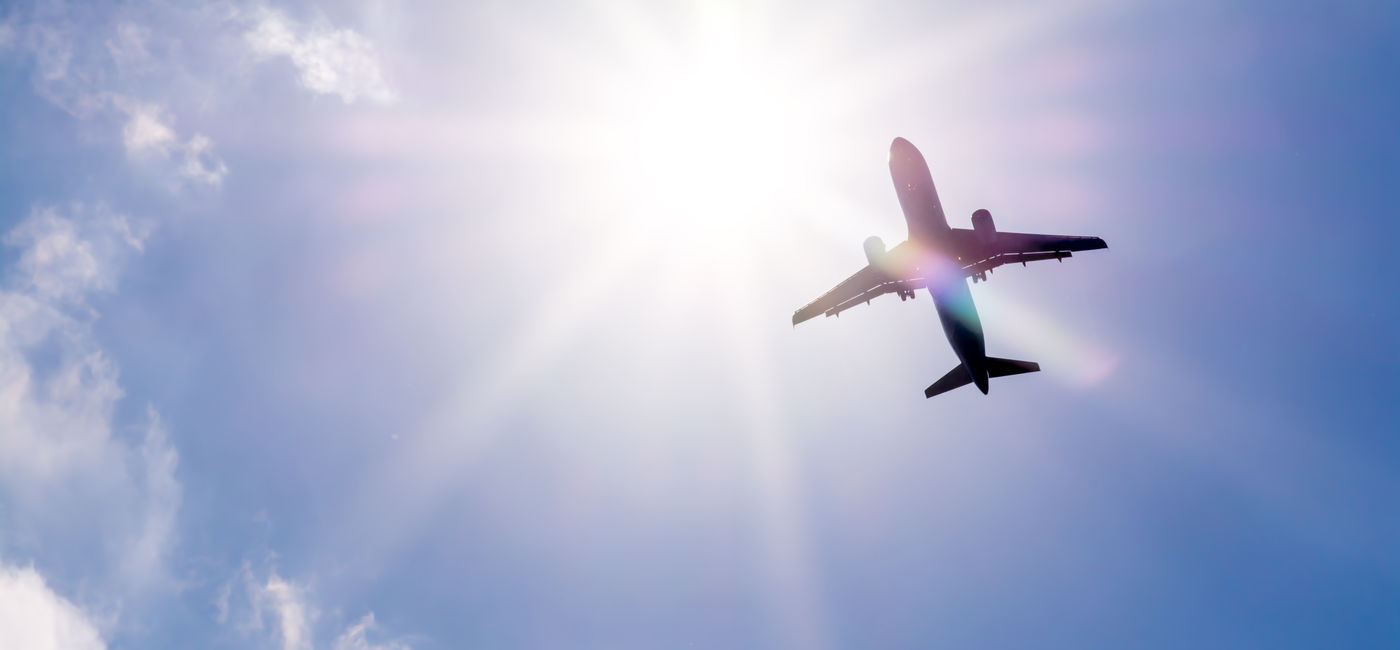 Image: Plane flying through clouds. (Photo Credit: denklim / Adobe Stock)