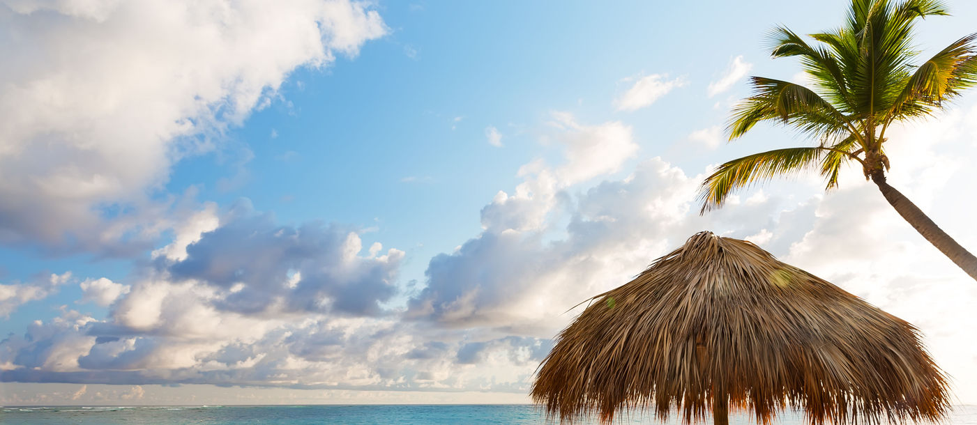 Beach chairs with umbrella and beautiful sand beach in Punta Cana, Dominican Republic (Photo via Preto_perola / iStock / Getty Images Plus)