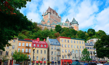 Chateau Frontenac in the day with colorful buildings on street in Quebec City (Photo via rabbit75_ist / iStock / Getty Images Plus)