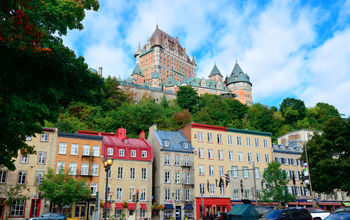 Chateau Frontenac in the day with colorful buildings on street in Quebec City (Photo via rabbit75_ist / iStock / Getty Images Plus)