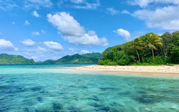 Island with turquoise water, white sand beach, blue sky