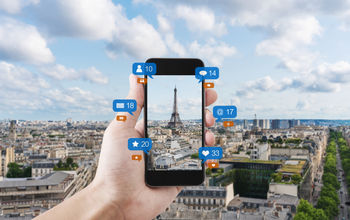 Smart phone taking a photo of the Eiffel Tower to post on social media.